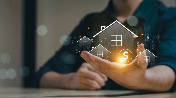 A person holding a glowing digital house icon with dollar signs, symbolizing real estate investment, property value, and financial growth.